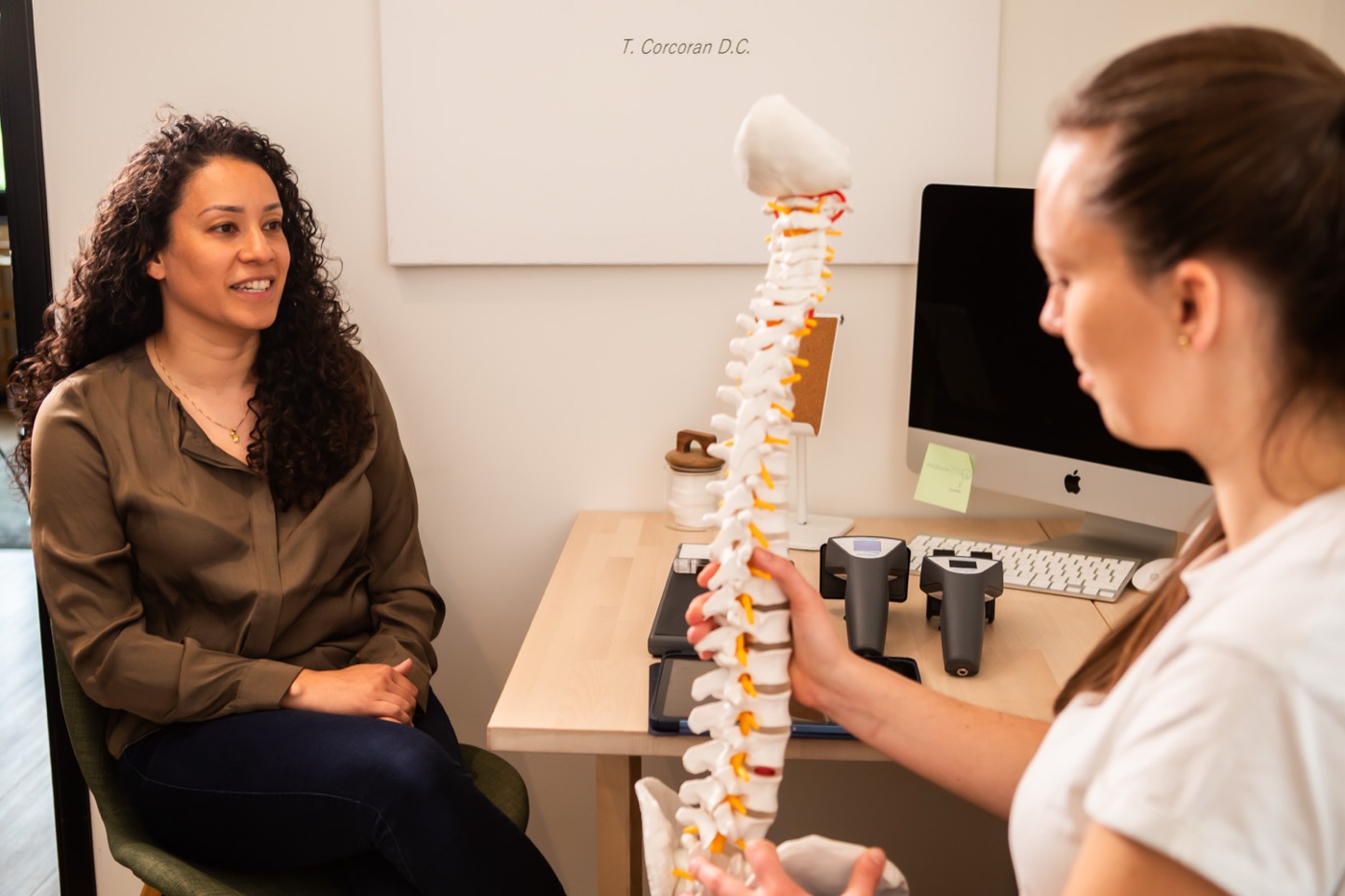 Chiropractor legt met een wervelkolommodel uit wat de scan laat zien bij TOPCHIRO Alphen aan den Rijn